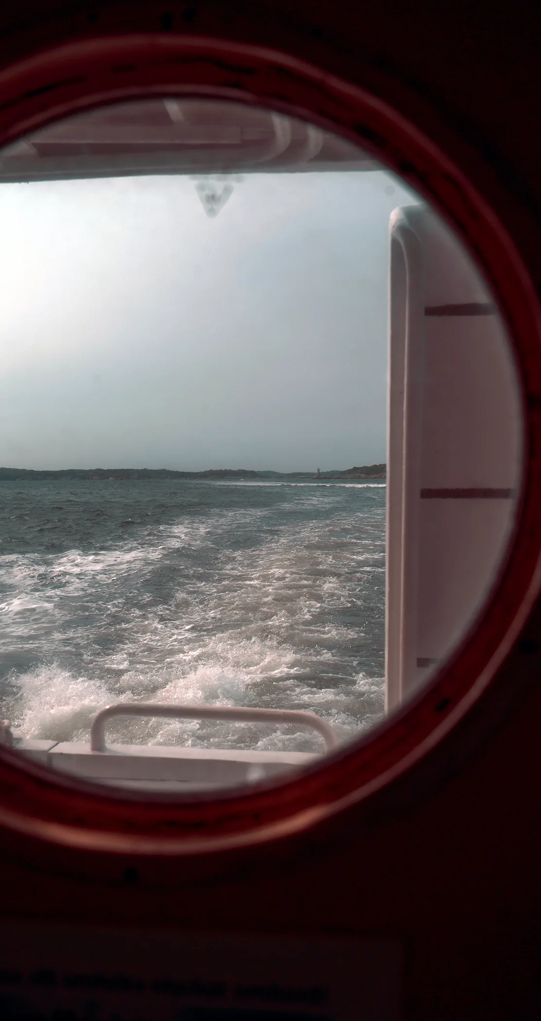 The ferry wake seen through a round porthole, Gothenburg archipelago