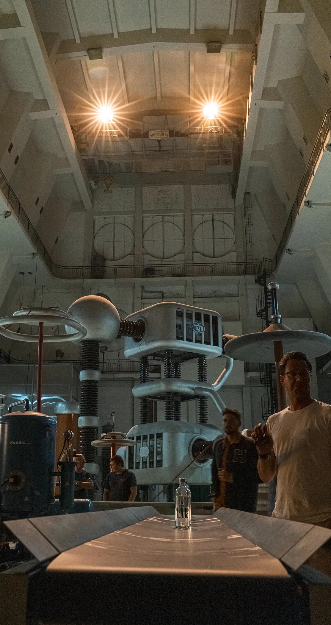 Crew gathered among the generators of a high-voltage hall, Prague