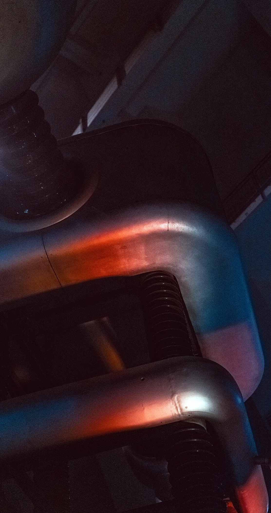 Curved steel conductors catching red light in a high-voltage lab